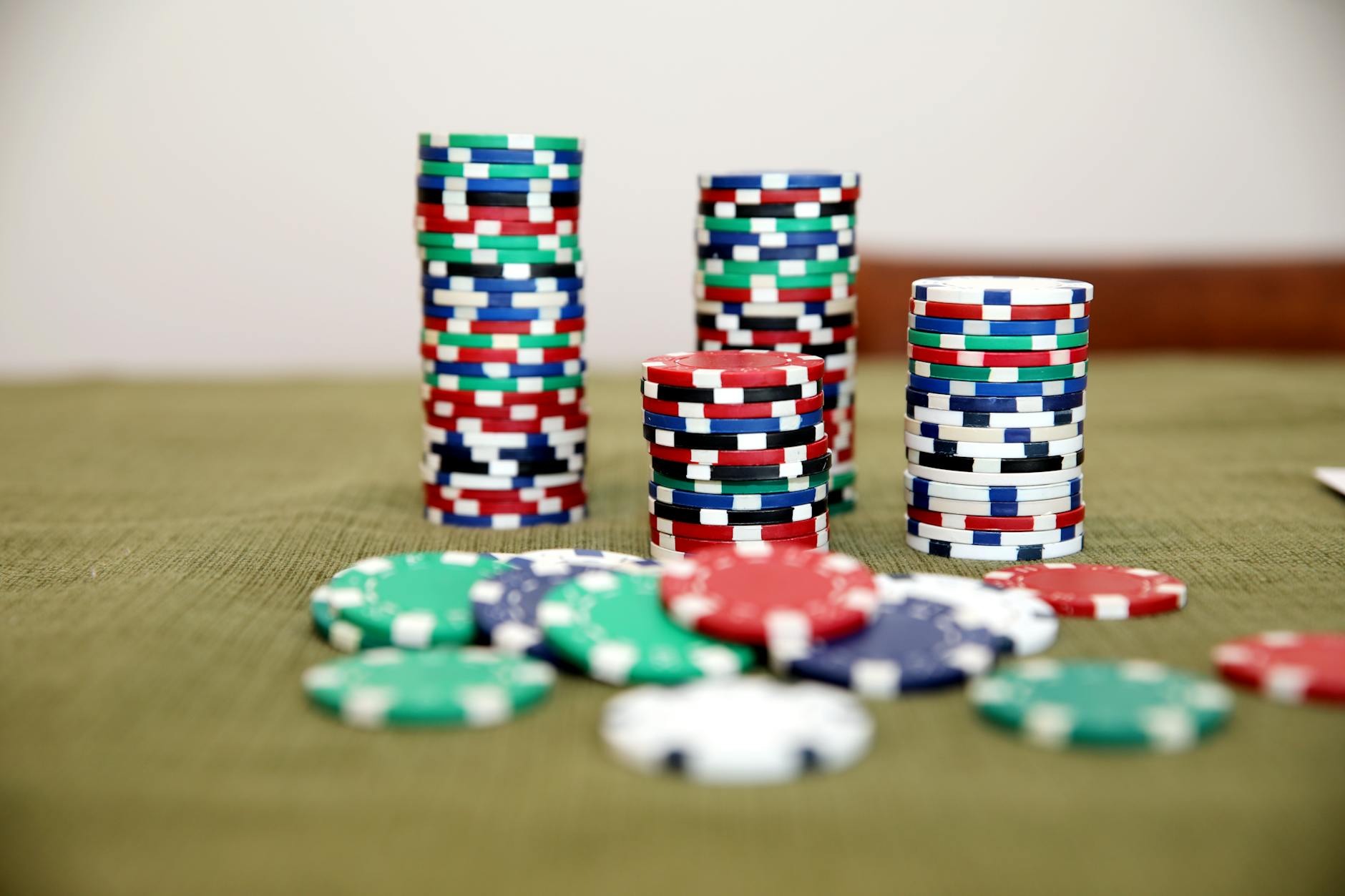 Stacks of colorful poker chips on a green table ready for a game.