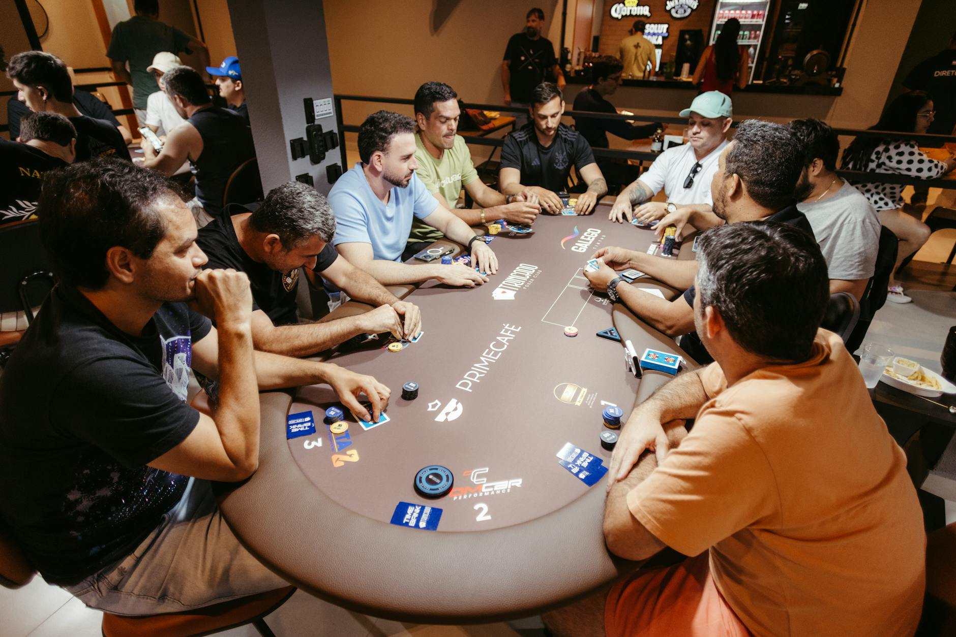 Group of adults playing poker at a Prime Café table, showcasing strategy and focus.