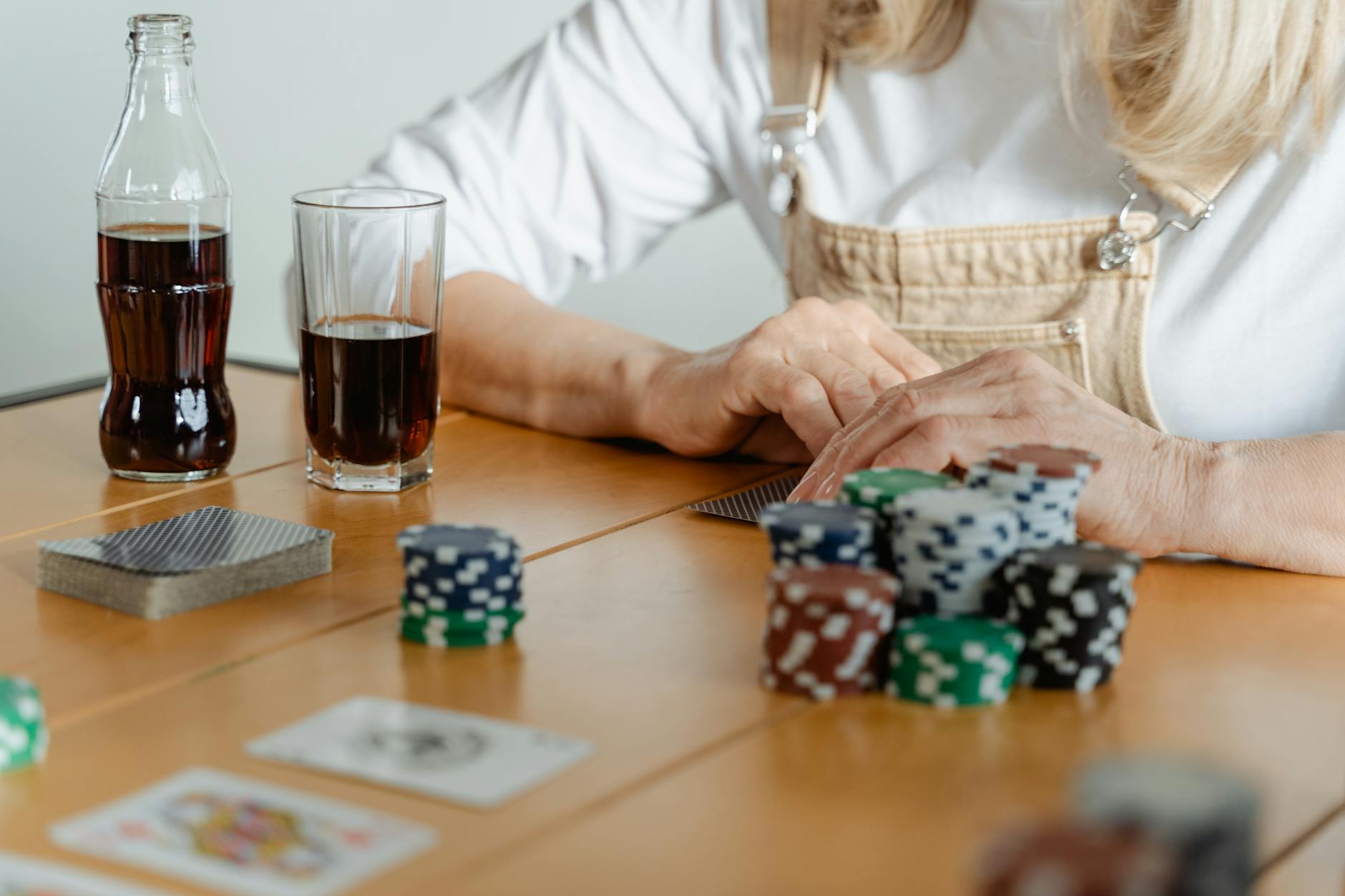 A casual poker game setup with playing cards, poker chips, and refreshing cola drinks.